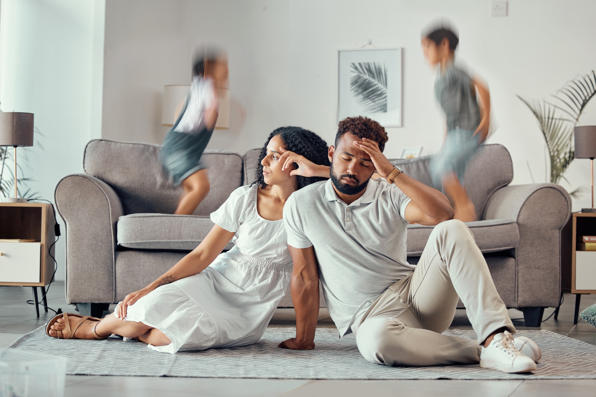 Stress, tired and parents with adhd kids playing on couch making mom sad, exhausted and frustrated